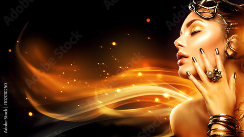 Burning woman head profile. Beauty fashion model girl with golden makeup