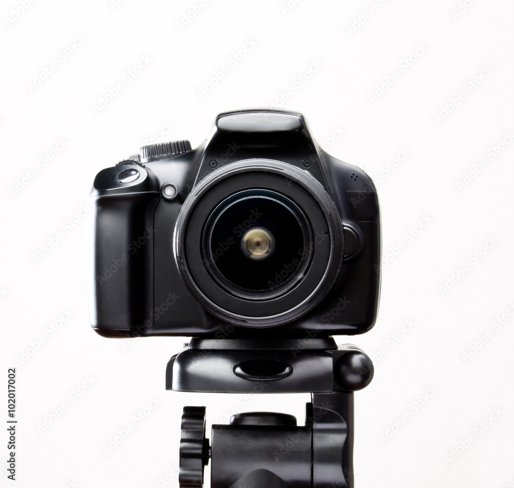 SLR camera on a tripod close-up shot on white background