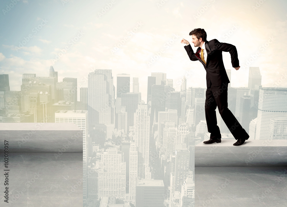 Businessman standing on the edge of rooftop Businessman standing on the edge of rooftop