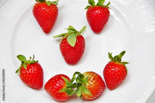 red strawberries on a white plate flat