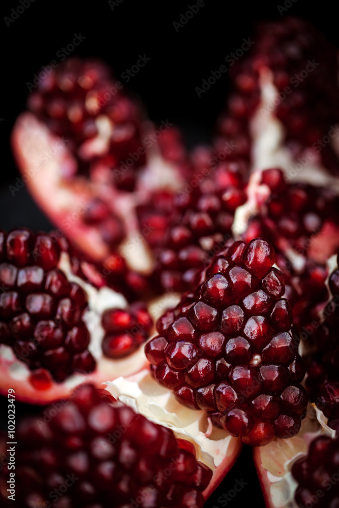 Fresh pomegranate and seeds on black Fresh pomegranate and seeds on black