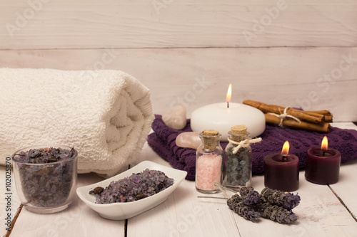Lavender flower and bath salts spa, two purple candles and a white towel