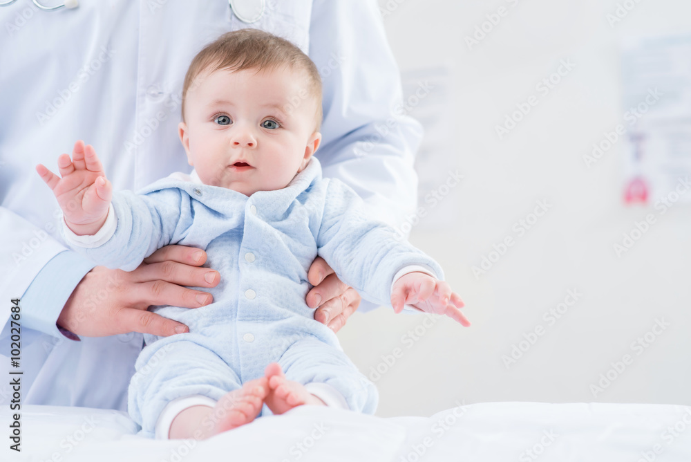 Professional pediatrician holding infant Professional pediatrician holding infant