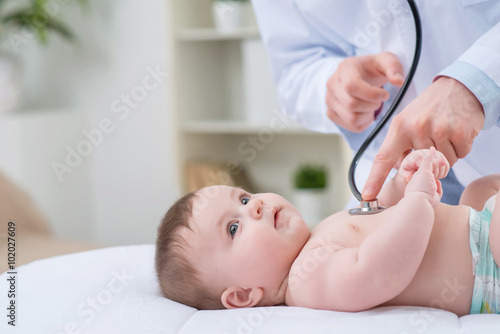 Professional pediatrician examining infant  photo