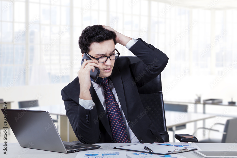 Depressed worker speaking on the phone Depressed worker speaking on the phone