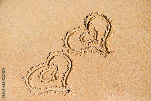 Double Love hearts impression on the sand background