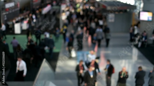 Out of focus shot of a busy building hallway, people walking about everywhere