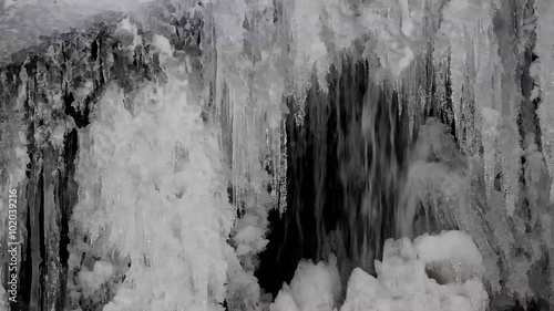 A small waterfall streaming behind frozen iceicles, shot with a canon 6D photo