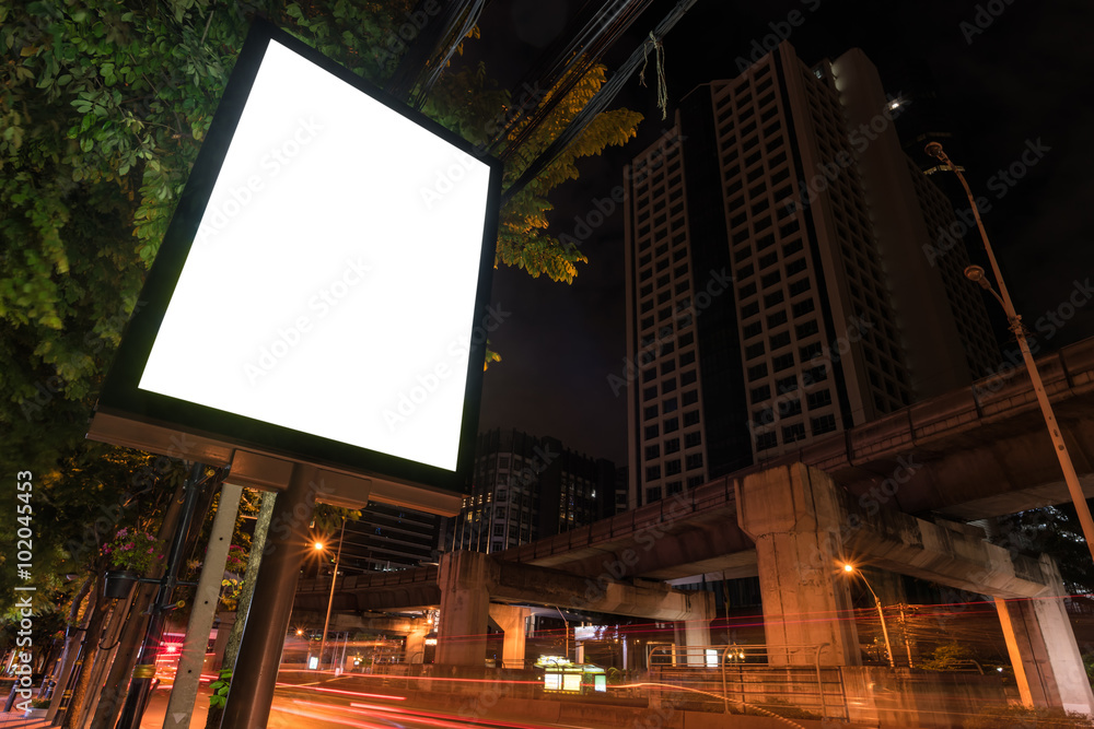 Blank billboard on city street at night