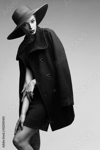 high fashion portrait of elegant woman in black hat and coat.