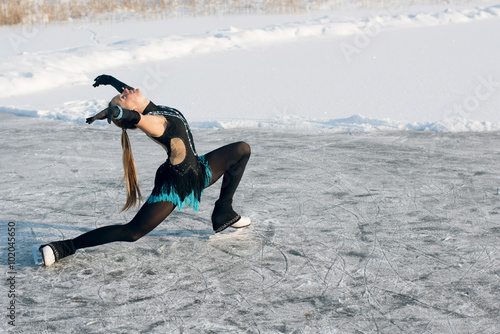 young Figure skating woman at the frozen lake in the winter