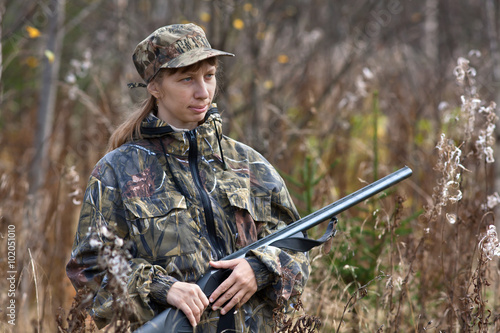 woman in camouflage on the hunting in autumn forest
