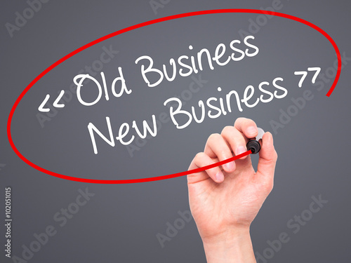 Man Hand writing Old Business - New Business with black marker o