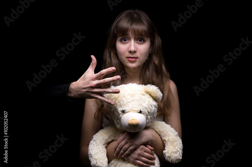 Fotografie Fearful teenage girl with toy