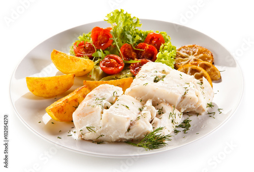 Fish dish - boiled fish fillet, baked potatoes and vegetables 