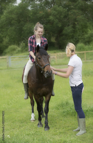 Riding bareback a teenage girl with her pet pony and an instructor