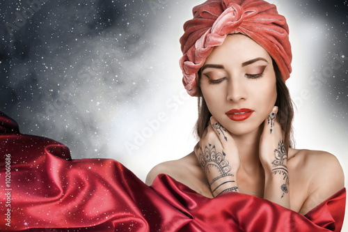 beautiful stylish woman in oriental style with mehendy wearing in turban . night. sky with stars. photo