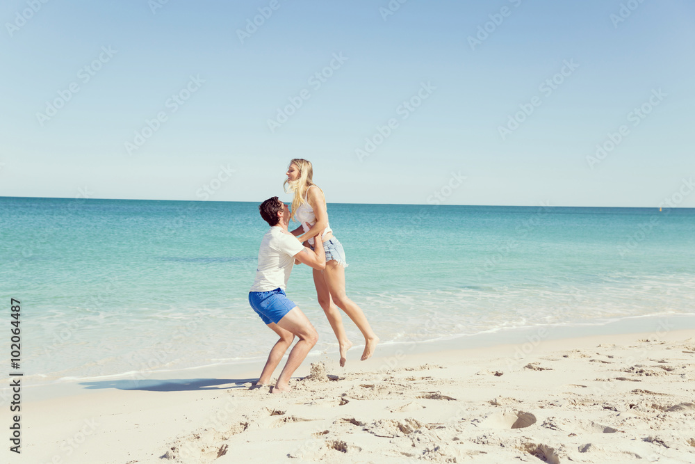 Happy couple jumping on beach vacations Happy couple jumping on beach vacations