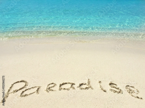 Inscription "Paradise" in the sand on a tropical island, Maldiv