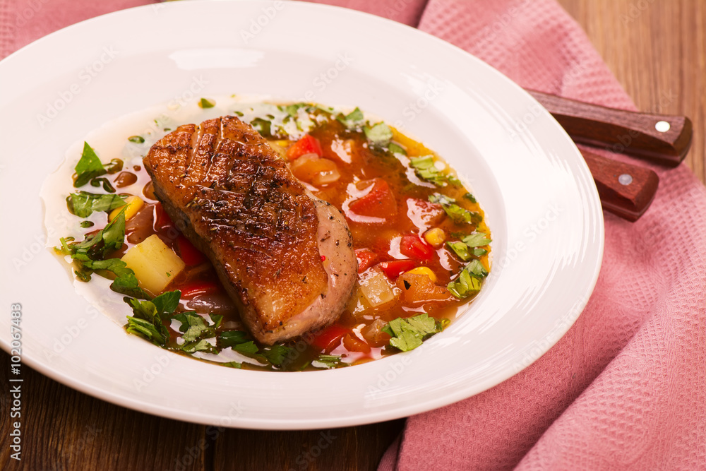 Spanish hot vegetable soup with duck breast. Rustic style. Toned image. Top view Spanish hot vegetable soup with duck breast. Rustic style. Toned image. Top view