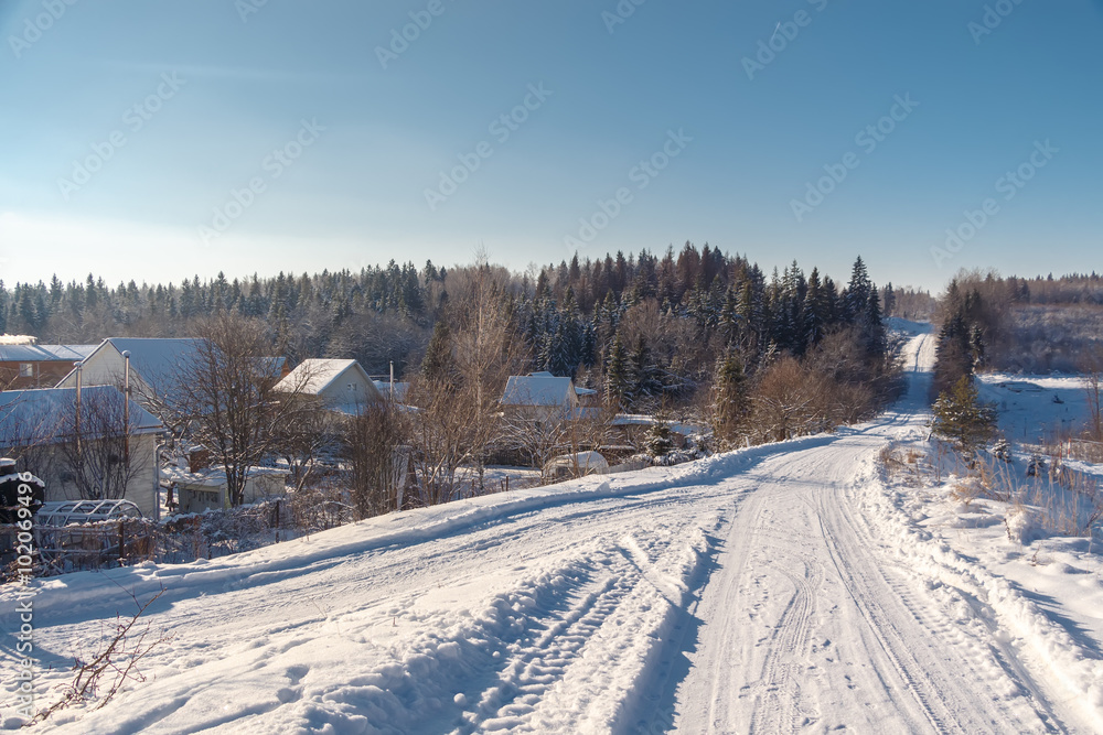Photo of the winter country road and village. Trees covered with snow. Winter landscape. Russia. Photo of the winter country road and village. Trees covered with snow. Winter landscape. Russia.