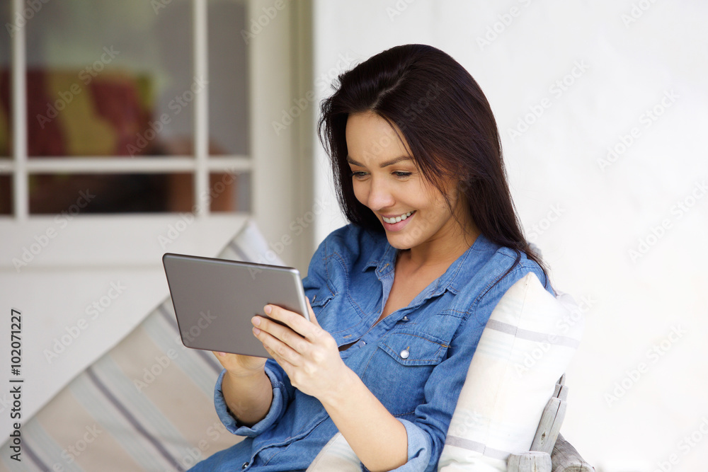 Young woman sitting at home using digital tablet Young woman sitting at home using digital tablet