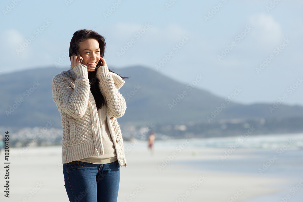 Cheerful young lady using mobile phone on the sea shore Cheerful young lady using mobile phone on the sea shore