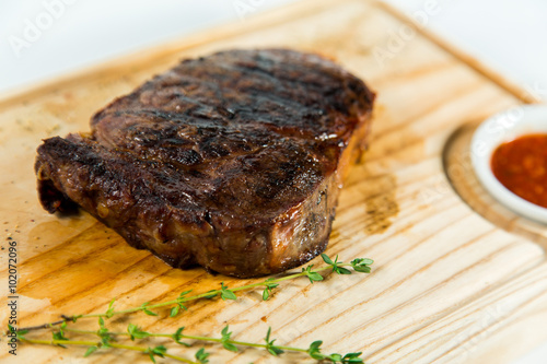 Beautiful juicy well done steak with sauce on a wooden Board photo