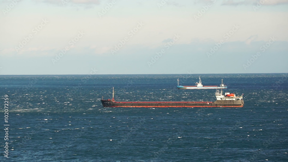 Dry cargo ships sailing into calm sea Dry cargo ships sailing into calm sea