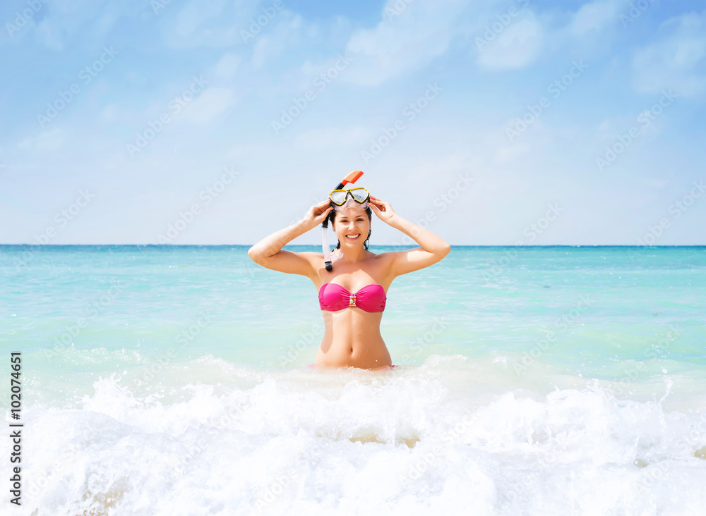 Beautiful, cheerful young woman with diving mask being happy in the wavy water. Beautiful, cheerful young woman with diving mask being happy in the wavy water.