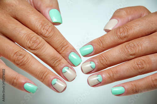 stylish beige and mint manicure on tanned hands