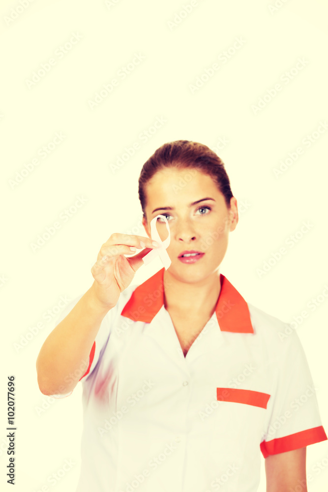 Young female doctor or nurse holding pink breast cancer awareness ribbon Young female doctor or nurse holding pink breast cancer awareness ribbon