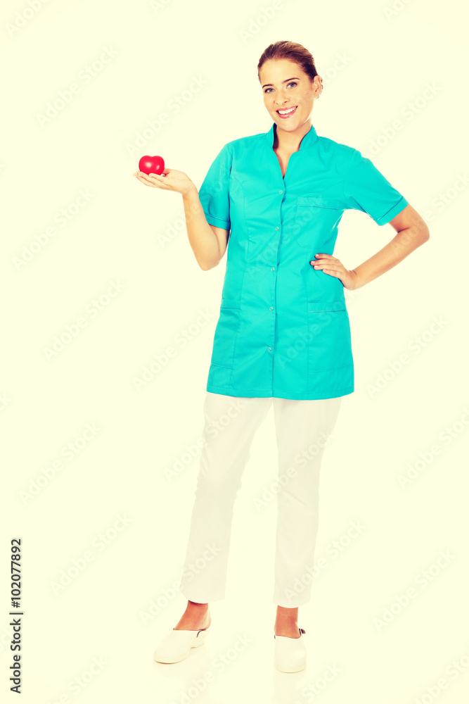 Young female doctor or nurse holding heart toy Young female doctor or nurse holding heart toy