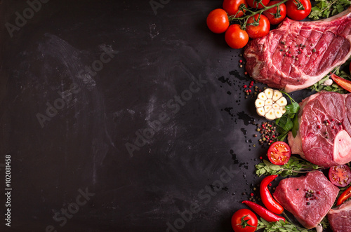 Raw meat steaks on a dark background ready to roasting