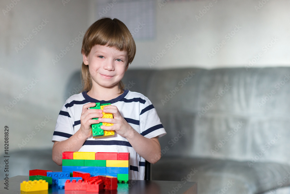 boy playing with lots of colorful plastic blocks indoor boy playing with lots of colorful plastic blocks indoor