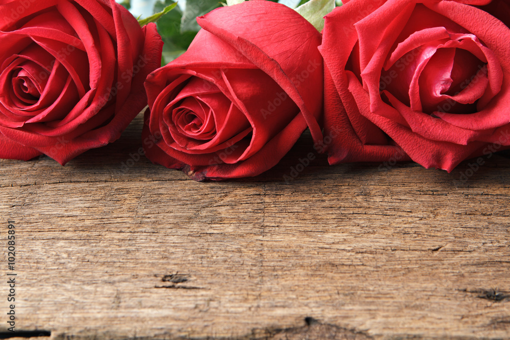 Valentines day background with closeup of roses on wooden.