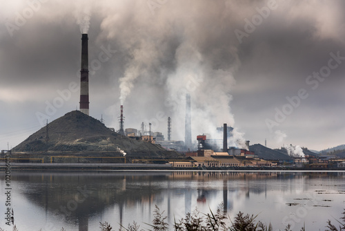 Silhouette of factory with chimneys and heavy smoke