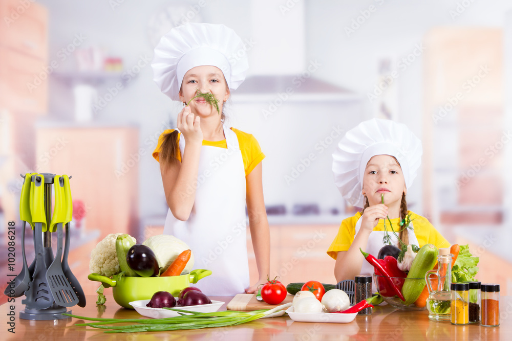 two girls cooks in the kitchen to prepare and show a mustache and beard two girls cooks in the kitchen to prepare and show a mustache and beard