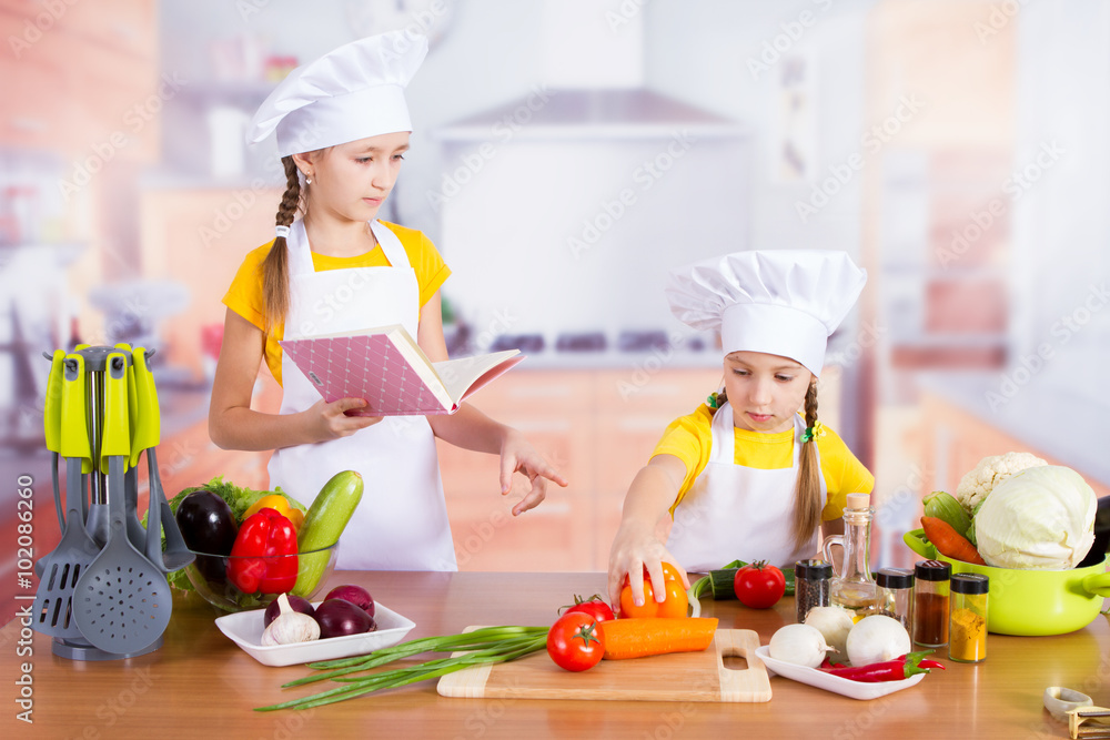 two girls looking for a recipe in the book two girls looking for a recipe in the book