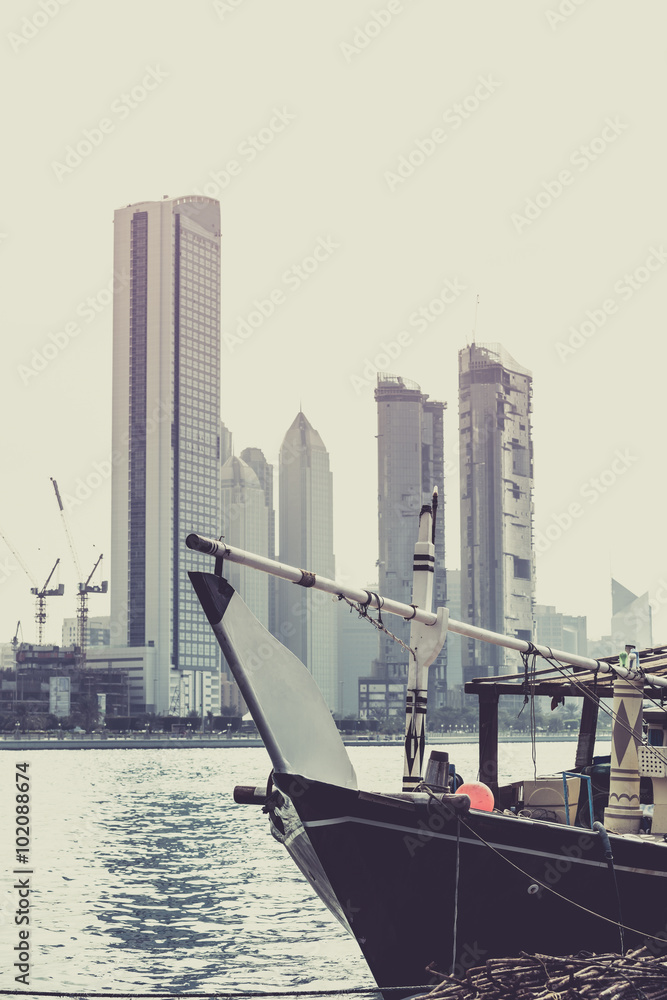 Fototapeta premium Abu Dhabi buildings skyline with old fishing boat