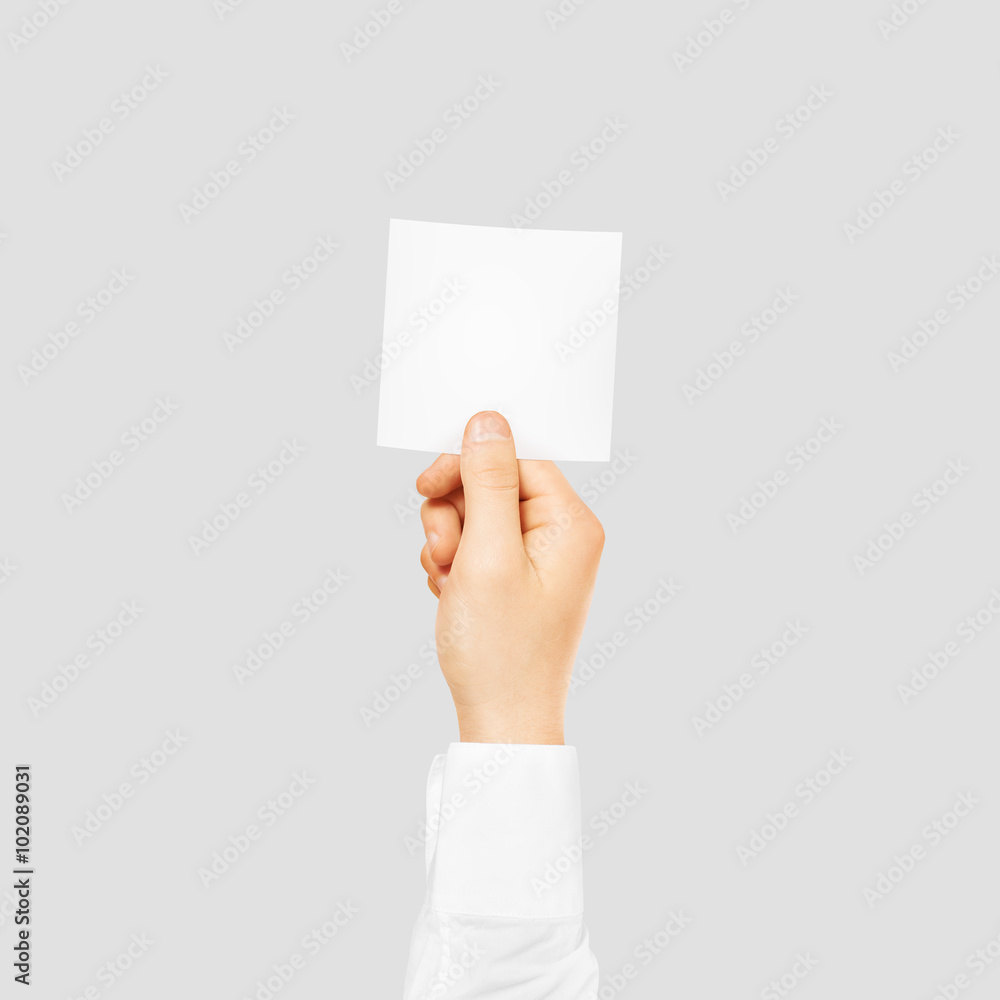 Hand holding square blank white sticker mock up isolated on gray. Hand holding square blank white sticker mock up isolated on gray.