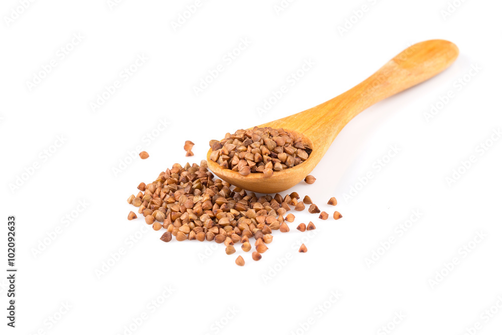 Uncooked buckwheat on wooden spoon Uncooked buckwheat on wooden spoon