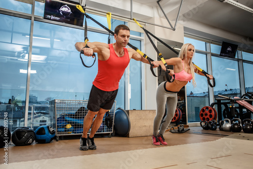 Muscular man and athletic woman doing exercises.