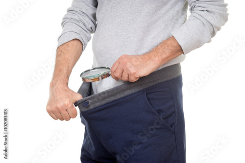 Man with magnifying glass looking into his tracksuit pants