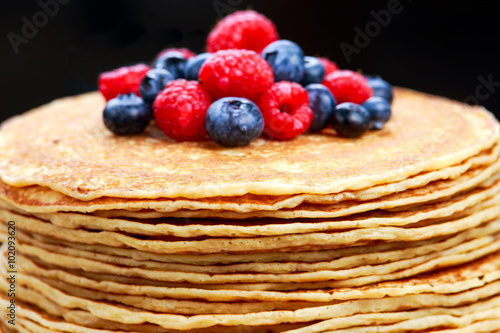 Fresh golden pancakes with raspberries, blueberries
