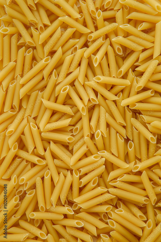 Uncooked Penne pasta on white background