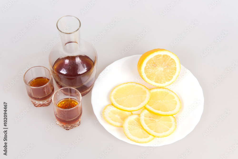The decanter of brandy, wine glasses and sliced lemons on a white background, appetizer for alcohol, meeting old friends, The decanter of brandy, wine glasses and sliced lemons on a white background, appetizer for alcohol, meeting old friends,