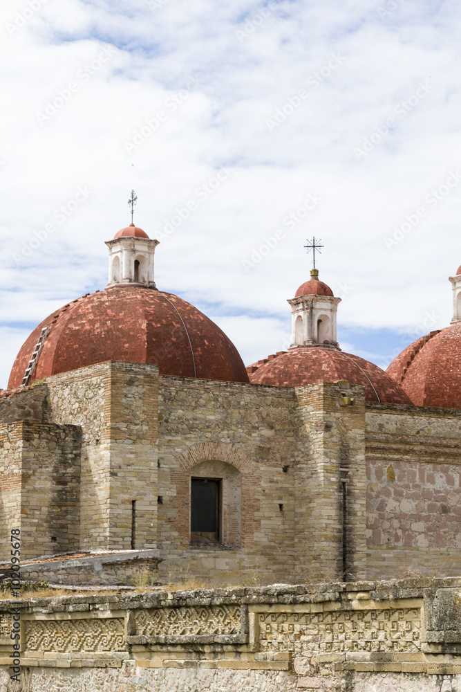 Church domes and indigenous Zapotec stone mosaics at Mitla archaeological site, Oaxaca, Mexico