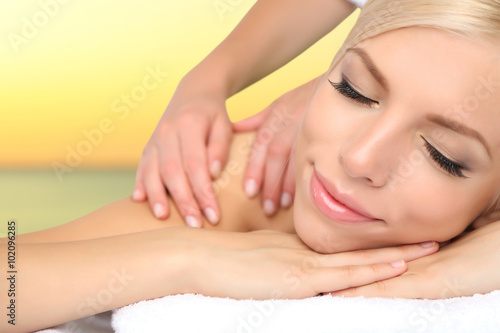 Beautiful young woman getting massage in spa salon
