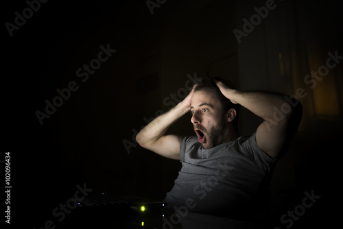 Hombre stresado por una mala noticia trabajando desde su casa por la noche photo